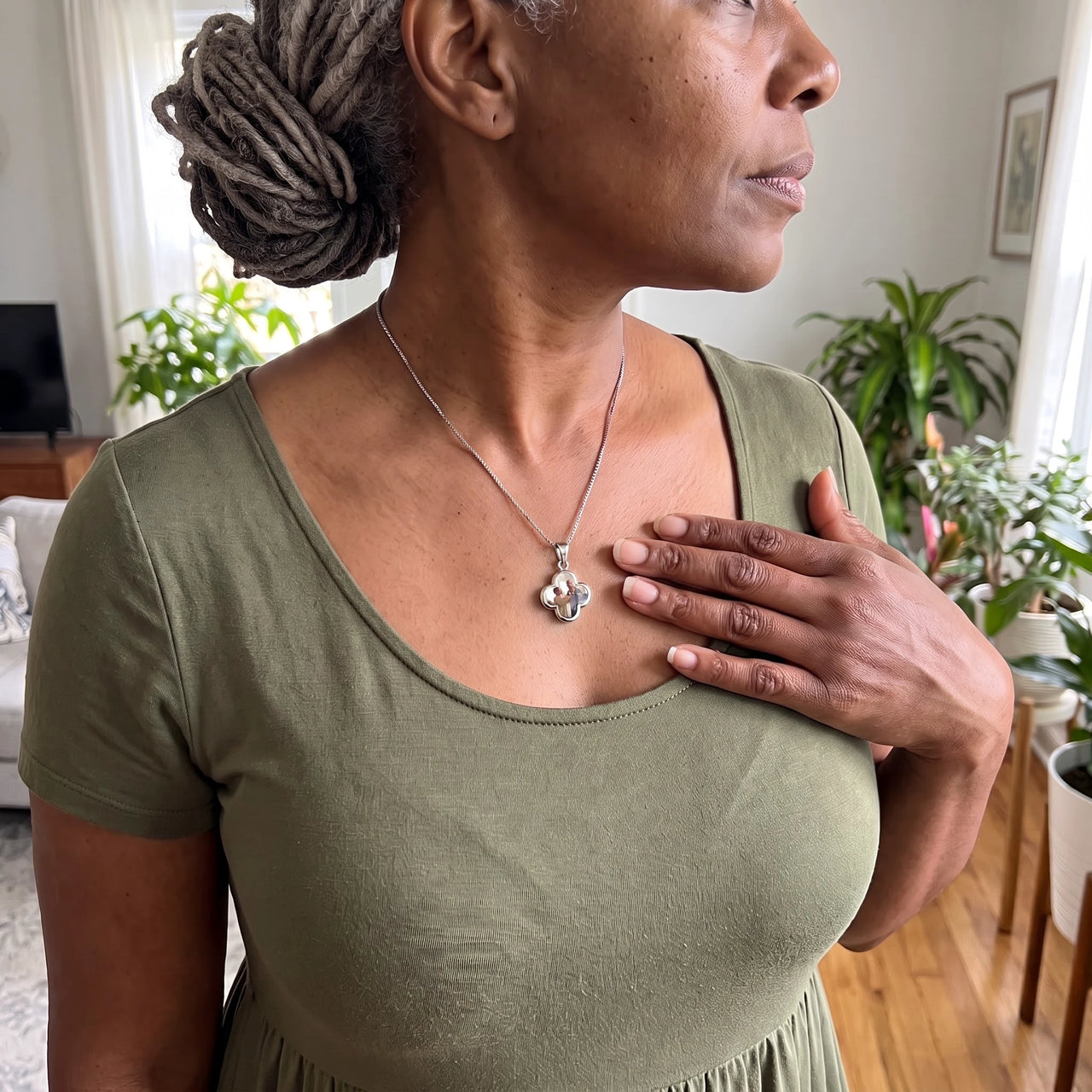 Woman in an olive dress with her hand on her heart, wearing the silver secret clover photo necklace | SKU: TPH-CLVN-SILVER