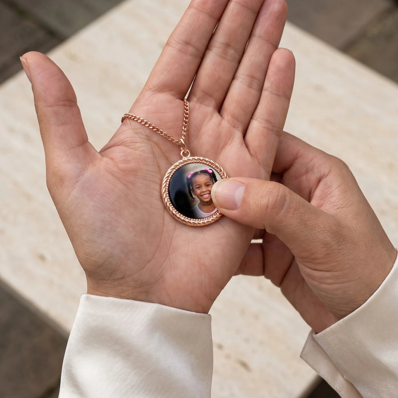 Thumb warming the rose gold round pendant: the hidden photo appears under the thumb while the rest stays black | SKU: TPH-RNDN-ROSEGOLD